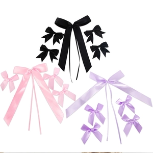 Dettaglio di fiocchi in raso fatti a mano in nero, rosa e lilla per decorazioni fai-da-te