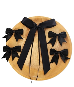 Set di fiocchi in raso nero di varie dimensioni su vassoio in legno per decorazioni