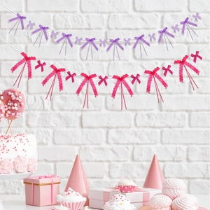 Coquette party decoration with purple and magenta bow garlands on a white wall