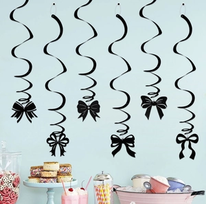Close-up of black swirl decorations with glitter bows for birthday party setup