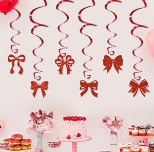 Close-up of pink glitter bow spiral pendants hanging over a festive party dessert table