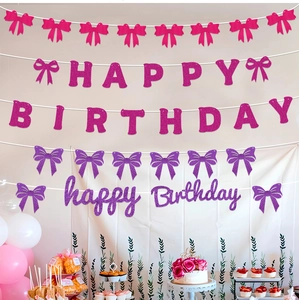 Macro detail of glitter pink and purple Happy Birthday banners with bow tie accents