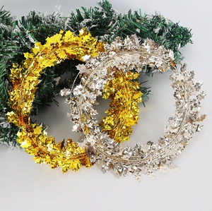 Detail of metallic gold and silver berry leaf tinsel garlands on festive pine branches