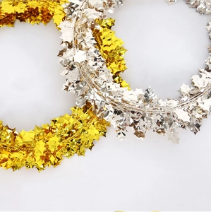 Detailed view of 7.5m gold and silver metallic tinsel garland with berry leaf shapes