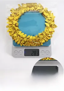 Detailed view of 7.5m gold leaf garland weighed on scale in packaging for party decor