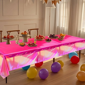 Rosafarbene holografische Tischdecke auf Partytisch mit Luftballons und Obstschale