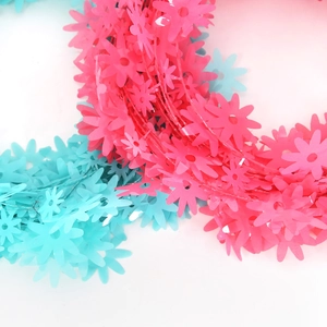 Dettaglio di ghirlanda di margherite rosa e blu in filo metallico lucido e flessibile