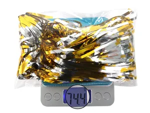 Weight measurement of gold and silver tinsel curtains showing approximately 74.4 grams