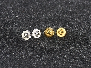 Macro view of gold and silver eagle stud earrings featuring detailed bird relief accents