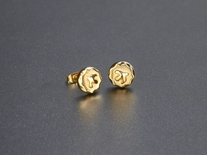 Detailed macro view of golden vintage eagle coin earrings with irregular wavy edges