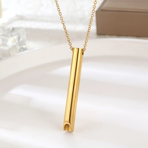 Collar de respiración dorado minimalista sobre una elegante superficie de cerámica blanca