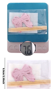 Detailed view of pink glitter bow cake toppers with wooden sticks and packaging