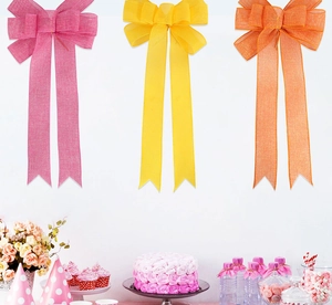Three large faux burlap bows in pink, yellow and orange for party and wall decoration