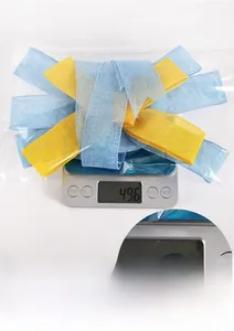 Weight measurement of blue and yellow bow decoration in packaging weighing 49.6g