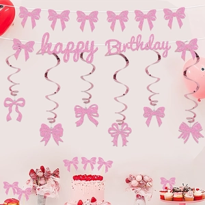 Close-up of pink glitter bow cake toppers and birthday banner for kids party decor
