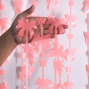 Dettaglio della tenda a frange rosa con fiocchi e stelle per decorazione di feste