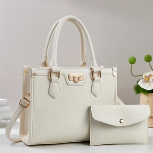 Close-up of cream white lychee texture tote bag and matching envelope clutch with gold hardware