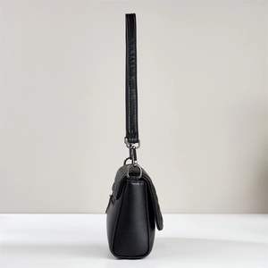 Detail view of the quilted black leather handbag showing side texture and metallic hardware