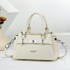 Detail of cream white leather handbag featuring silver hardware and fashion text engraving