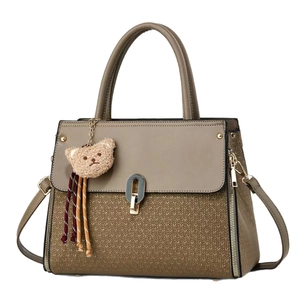 Two-tone brown leather handbag with V-weave texture, top handle, and cute bear pendant