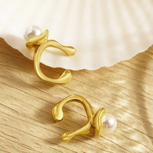 Irregular gold ear cuffs with pearls on a shell base for a minimalist luxury look