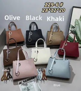 Detailed close-up of fashion tote bags in various colors with metallic ring decor