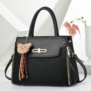 Elegant black faux leather and knit handbag with gold hardware and plush bear charm
