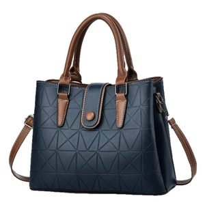 Navy blue geometric embossed leather handbag with brown handles and adjustable shoulder strap
