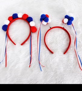Detail view of patriotic hair hoops with red white and blue pom-poms and flowing ribbons