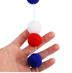 Detail of red white and blue felt ball garland for Independence Day party decor