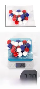 Detail showing weight and dimensions of red, white, and blue pom pom garland packaging