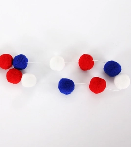 Detail of red white and blue soft pom pom garland for Independence Day party decor