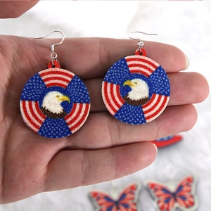 Macro detail of patriotic eagle and star-spangled banner earrings on acrylic finish