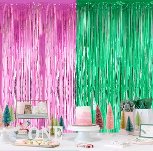 Pink and green foil fringe curtains used as a vibrant wicked themed party backdrop
