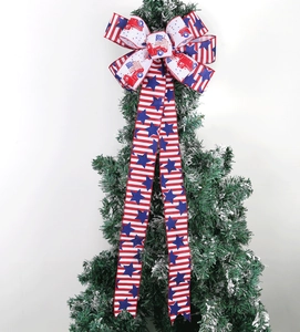 Macro detail of USA flag ribbon bow with red truck patterns on snow-covered pine tree