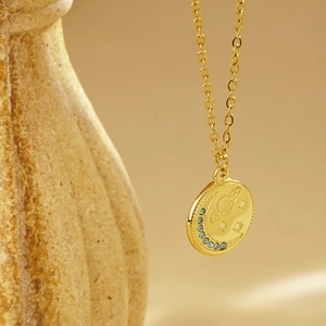 Collier doré avec pendentif lune planète circulaire et zircons bleus incrustés