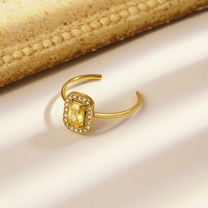 Gold open ring featuring a rectangular yellow gemstone surrounded by white zircons