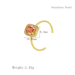 Detailed macro view of gold-plated stainless steel ring with orange square gemstone