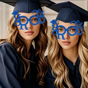 Close-up of blue glitter GRAD glasses with mini graduation cap and diploma details