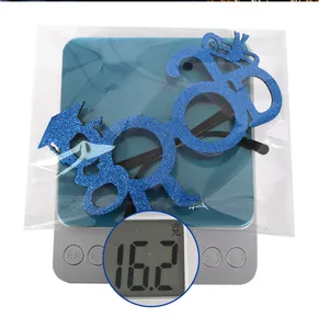 Detail of 2024 blue glitter graduation glasses weighing 16.2g on a scale