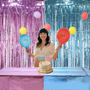 Pink and blue metallic tinsel curtain and balloons for baby gender reveal party