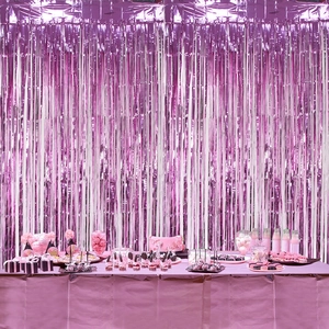 Gender reveal party set with magenta foil fringe curtain and shiny pink disposable tablecloth