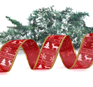 Detail of red Christmas ribbon with reindeer and snowflake prints and gold edges