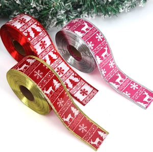 Close-up of Christmas decorative ribbons with reindeer and snowflake prints on white surface