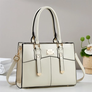 Sac à main beige élégant avec boucles dorées et bandoulière dans un décor épuré