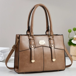 Détail du sac cabas marron avec plaque en métal doré et texture en cuir grainé