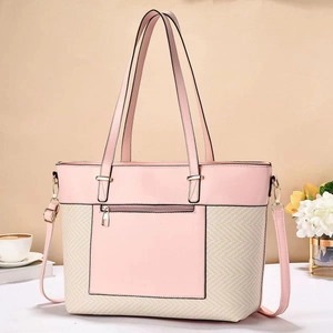 Dettaglio di una grande borsa tote rosa e beige con tasca a zip e tracolla regolabile