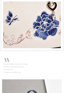 Detail of blue floral and butterfly embroidery on a beige leather tote with heart charm