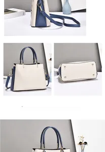 Detailed view of cream and navy tote bag with gold protective bottom studs and dual straps
