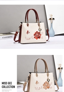 Detail of elegant Chinese style floral embroidery on a premium leather handbag with heart charm